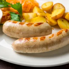 Dwie białe kiełbaski z grilla, ziemniaczki, surówka i musztarda. Idealne danie, gdy zastanawiasz się, co zrobić z białej kiełbasy.