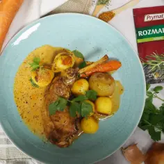 Pyszne udka z królika pieczone w piekarniku z ziemniakami i marchewką w sosie, doprawione rozmarynem.