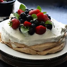 Pavlova z owocami leśnymi, idealna po upieczeniu w niskiej temperaturze.