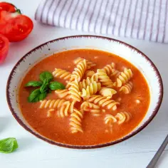 Aksamitny, pomidorowy smak z makaronem fusilli. Idealna ilość przecieru do zupy pomidorowej, udekorowana bazylią.