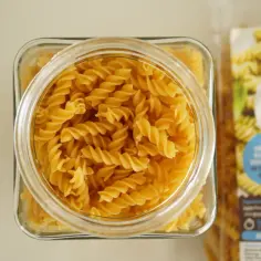 Słoik pełen makaronu fusilli, obok opakowanie z napisem "LOVE GIO". Idealny wybór dla dbających o niski indeks glikemiczny.