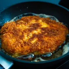 Złocisty kotlet schabowy smaży się na patelni. Dowiedz się, ile smażyć kotlety schabowe żeby były miękkie i chrupiące.