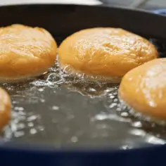 Pączki smażą się w gorącym tłuszczu. Idealna temperatura tłuszczu do smażenia pączków zapewnia im złocisty kolor i chrupkość.