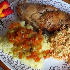 Pyszny królik pieczony w rękawie z warzywami, podany z puree ziemniaczanym i surówką z marchewki.