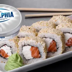 Rolki sushi z łososiem i kremowym serkiem, idealne co zamiast serka Philadelphia. Obok opakowanie serka Philadelphia.