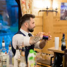 Barman przygotowuje drinki na wesele. Zastanawiasz się, ile kosztuje barman na wesele? Ten profesjonalista z pewnością doda uroku każdej imprezie.