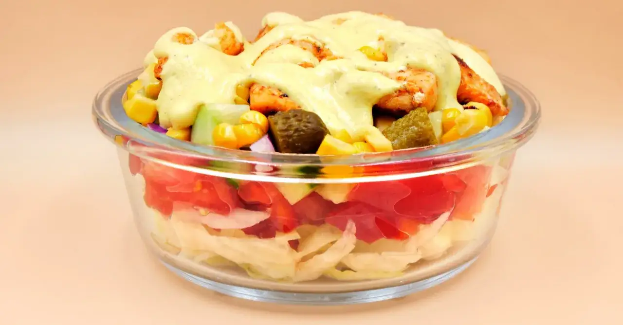 Sałatka gyros w szklanej misce z kurczakiem, kukurydzą i sosem. Zastanawiasz się, ile może stać sałatka gyros w lodówce?