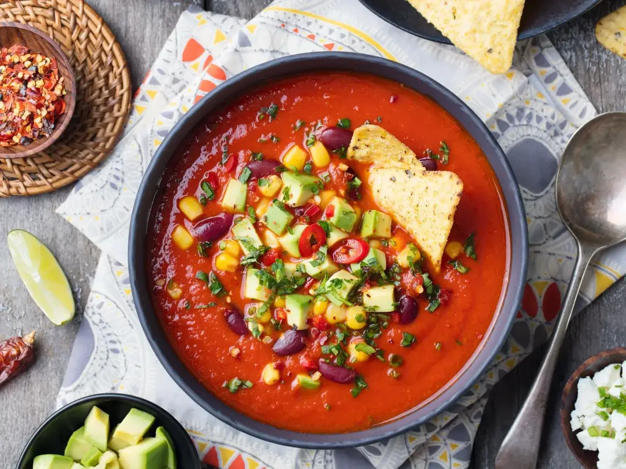 Zupa pomidorowa z awokado, kukurydzą i fasolą. Co dodać do zupy pomidorowej? Może nachos i posiekane chili?