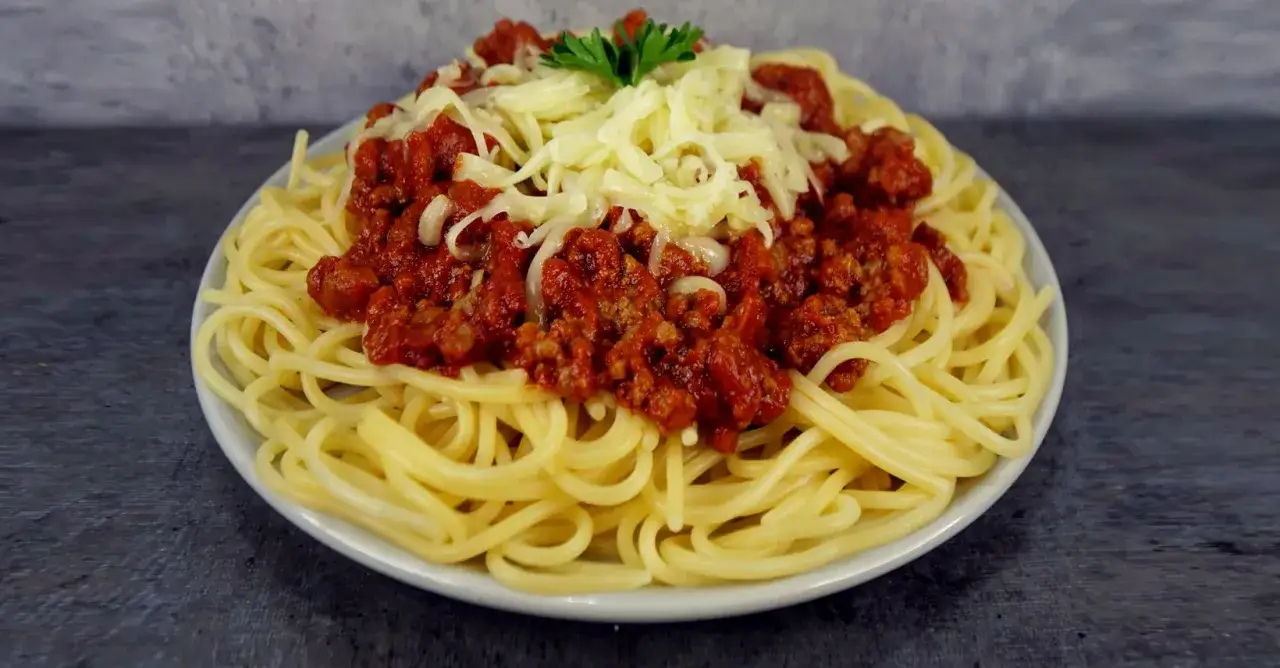 Porcja spaghetti bolognese z serem i natką pietruszki. Zastanawiasz się, ile kcal ma spaghetti bolognese?