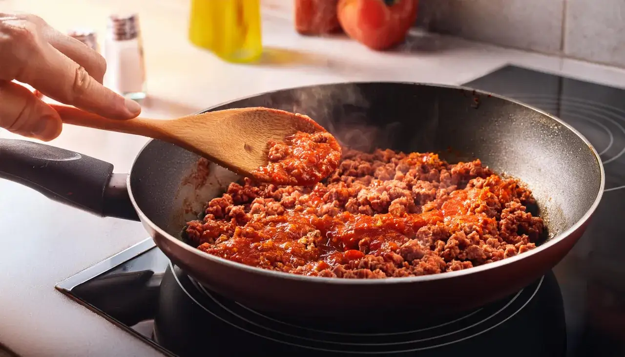 Mielone mięso z sosem pomidorowym na patelni. Czy spaghetti bolognese jest zdrowe? Zależy od składników!