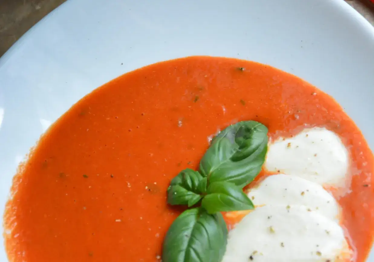Aksamitny, pomidorowy przecier do zupy, ozdobiony listkami bazylii i kuleczkami mozzarelli. Idealny na szybki obiad.