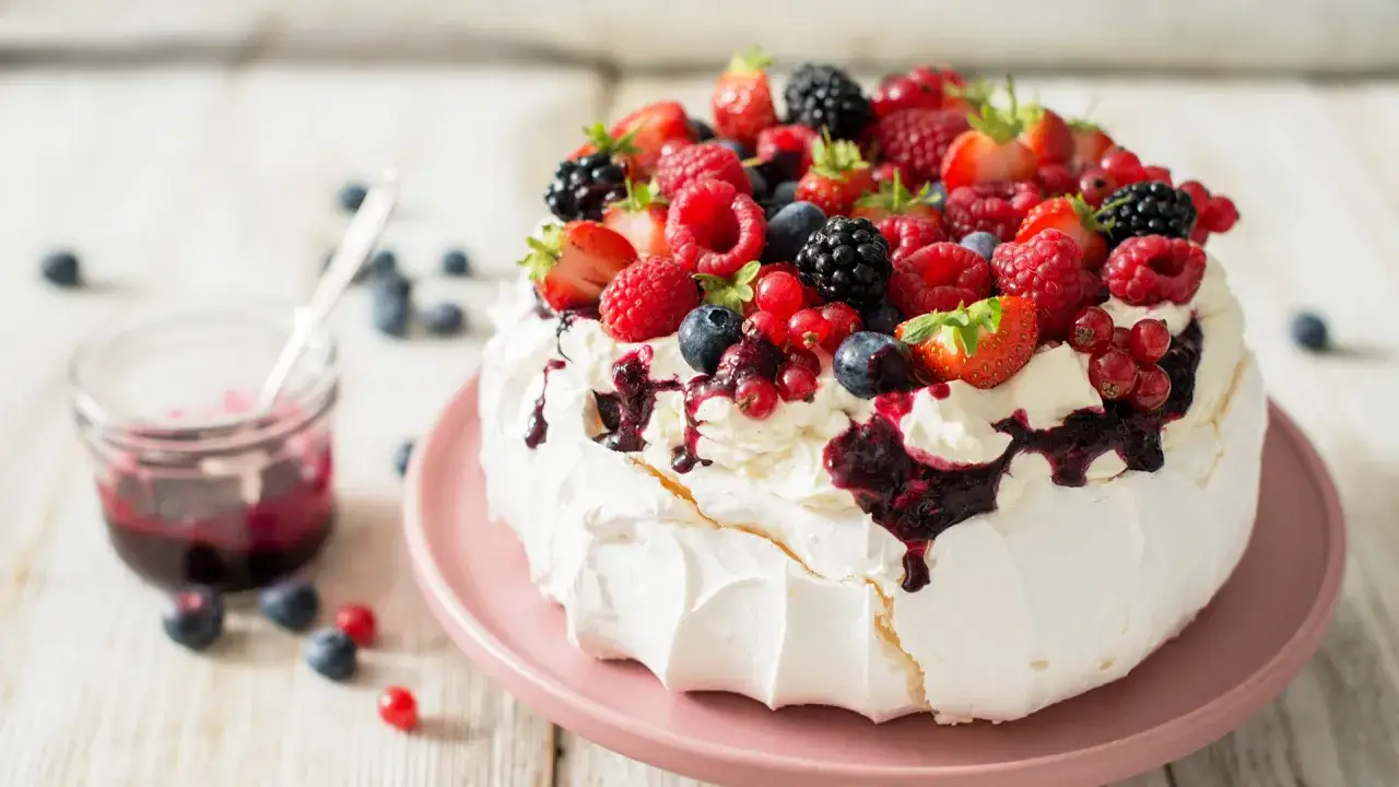 Bezy ile piec? Ta Pavlova z owocami leśnymi i bitą śmietaną wygląda pysznie!