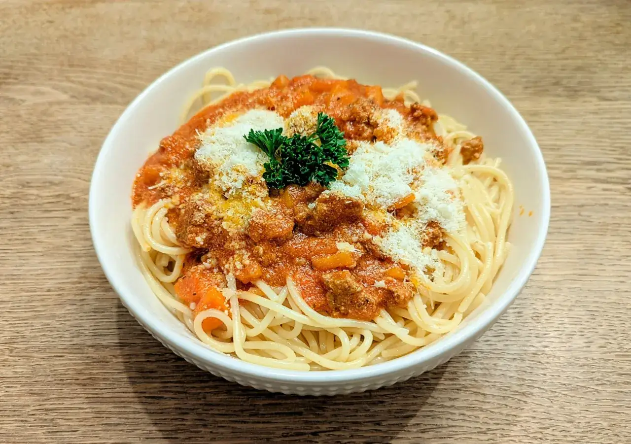 Porcja spaghetti bolognese z parmezanem i natką pietruszki. Zastanawiasz się, ile kcal ma spaghetti bolognese?