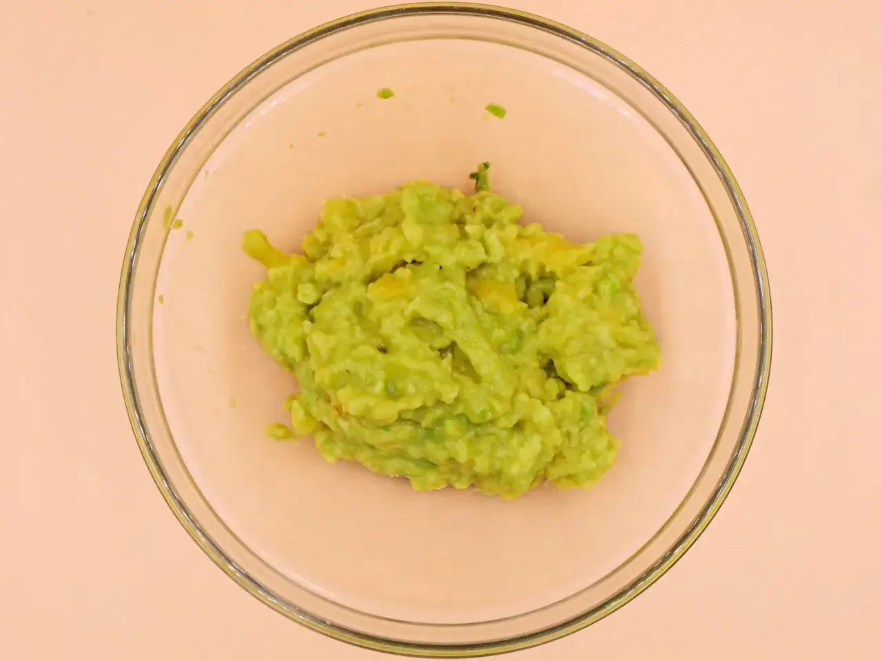 Zielone, rozgniecione awokado w szklanej misce. Czy guacamole jest zdrowe? Tak, to pyszna i zdrowa przekąska!