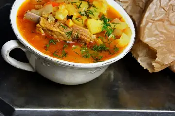 Gęsta, aromatyczna zupa na żeberkach z ziemniakami i marchewką, posypana świeżym koperkiem.